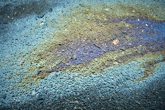 Oil stain on asphalt creating an abstract background from spilled motor oil, gasoline, or petrol