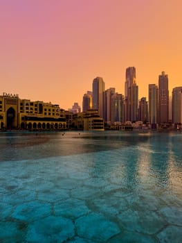 UAE, Dubai, 26 December 2024: The famous shopping center Dubai Mall and Burj Khalifa skyscraper at dusk, Dubai's sights and skyscrapers illuminated at night, palm trees. High quality photo