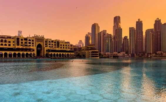 UAE, Dubai, 26 December 2024: The famous shopping center Dubai Mall and Burj Khalifa skyscraper at dusk, Dubai's sights and skyscrapers illuminated at night, palm trees. High quality photo