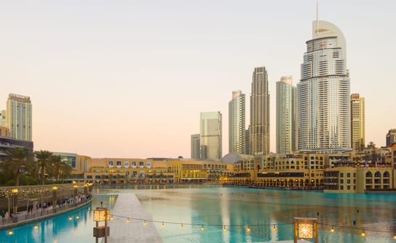 UAE, Dubai, 11 December 2024: The famous shopping center Dubai Mall and Burj Khalifa skyscraper at dusk, Dubai's sights and skyscrapers illuminated at night, palm trees. High quality photo