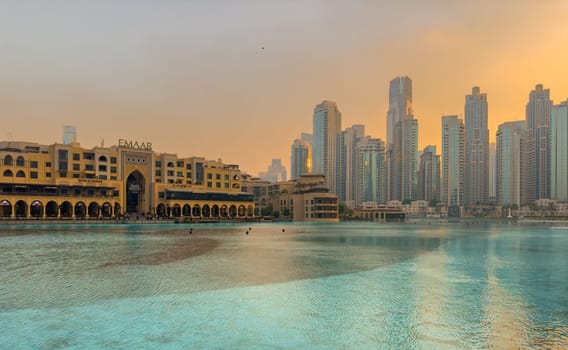 UAE, Dubai, 26 September 2024: The famous shopping center Dubai Mall and Burj Khalifa skyscraper at dusk, Dubai's sights and skyscrapers illuminated at night, palm trees. High quality photo