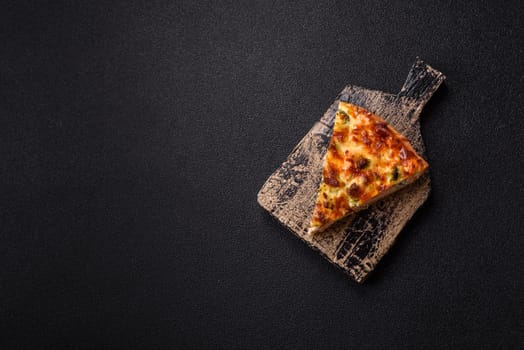 Delicious fresh quiche with broccoli, cheese, spices and herbs cut into pieces on a dark concrete background