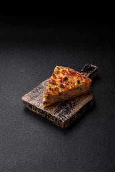 Delicious fresh quiche with broccoli, cheese, spices and herbs cut into pieces on a dark concrete background