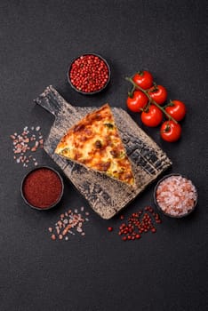 Delicious fresh quiche with broccoli, cheese, spices and herbs cut into pieces on a dark concrete background