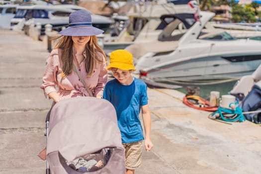A mother and her elder son enjoy a peaceful walk along the waterfront, pushing a baby stroller with their youngest family member. A heartwarming moment of family bonding, parenting, and outdoor leisure.