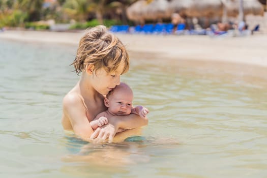An older brother gently holds his baby sibling while swimming in the sea, sharing a joyful and heartwarming moment of family bonding and summer fun in the water. A perfect blend of love, care, and childhood adventure.