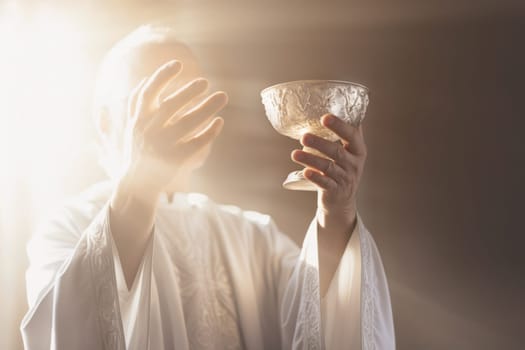 Eucharistic body of Christ. Priest holding a chalice with consecrated hosts during a mass celebration. Holy Communion. The elevation of the goblet with the blessed sacrament during the Catholic Liturgy of the Eucharist. Sacred bread. IHS