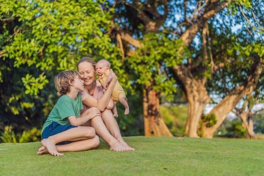 Young mother, teenage son, and one-month-old baby enjoying quality family time in the park. Multigenerational bonding and outdoor family love concept.