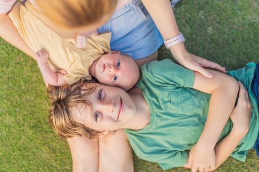 Young mother, teenage son, and one-month-old baby enjoying quality family time in the park. Multigenerational bonding and outdoor family love concept.