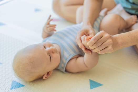 A mother gently massages her baby tiny fingers and palms, promoting relaxation and stimulation. A tender bonding moment focused on care, love, and early development. Baby care, touch therapy, and nurturing concept.