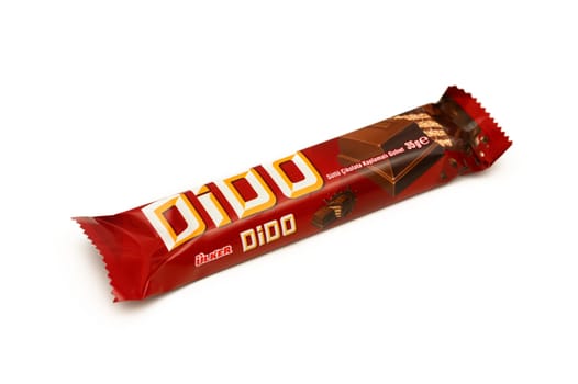 Gaziveren Cyprus -10.02.2025 A tempting chocolate bar wrapped in a bright red package sits appealingly on a white surface, waiting to be tasted.