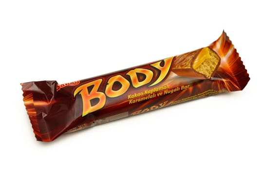 Gaziveren Cyprus -10.02.2025 Brightly packaged chocolate bar featuring caramel and nougat, lying elegantly on a clean, neutral background.