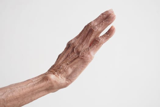 An elderly hand extends outward in a warm welcoming gesture.