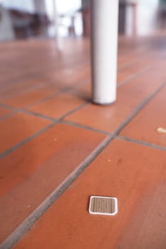 a phone sim card dropped on a tiles floor. lost sim card concept ,