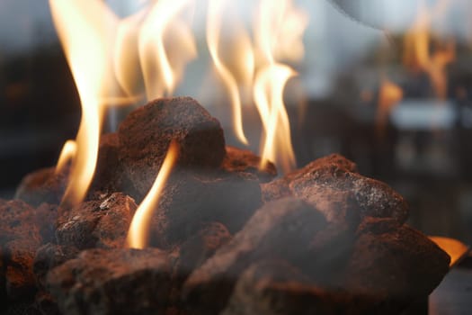 Flickering flames illuminate dark rocks in a soothing outdoor setting.