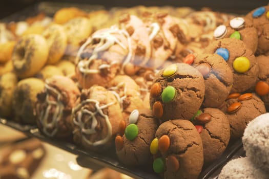 Colorful cookies with various toppings attract customers in the bakery.