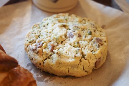 A delicious cookie rests on parchment, fresh from the oven.