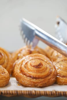 Delicious cinnamon rolls glisten with glaze on a decorative tray.