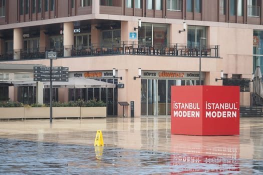 Modern art center stands prominently in a city plaza on a rainy day.