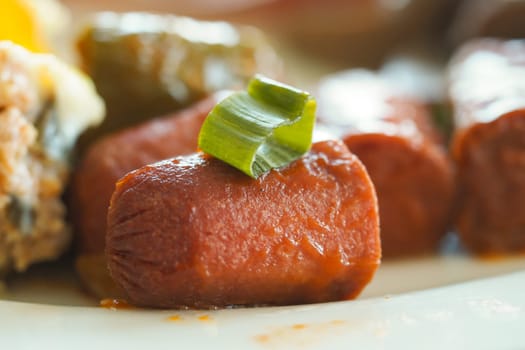 Tasty sausages with a colorful garnish in a warm environment.