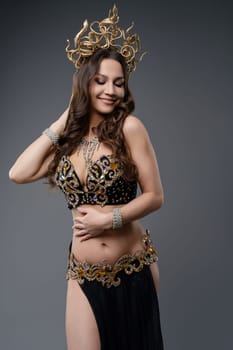 A skilled dancer performs in a stunning outfit adorned with intricate details and a majestic headdress, exuding confidence and beauty.