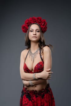 Belly dancer showcases her artistry with an elegant outfit and a floral crown in a professional studio.