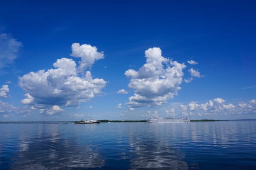 Summer landscape on the river with clouds in the blue sky. High quality photo
