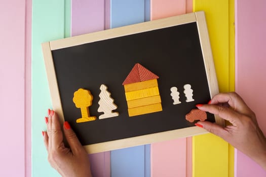 Women's hands lay out figures made of cubes on the board. High quality photo