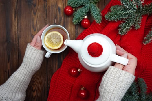 Women's hands pour tea from a teapot into a cup. High quality photo