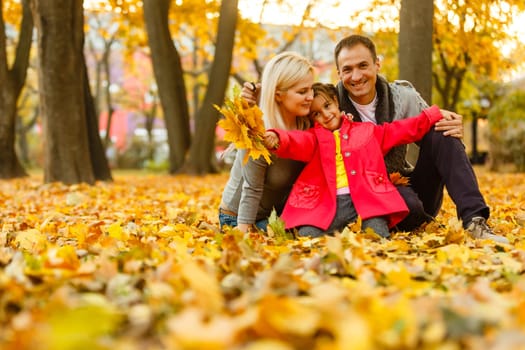 Family playing in autumn park having fun.