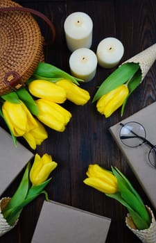 Yellow tulips comfortably laid out on the table in a wicker bag and in waffle cones. High quality photo