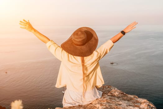 Portrait of happy young woman wearing summer black hat with large brim at beach on sunset. Closeup face of attractive girl with black straw hat. Happy young woman smiling and looking at camera at sea