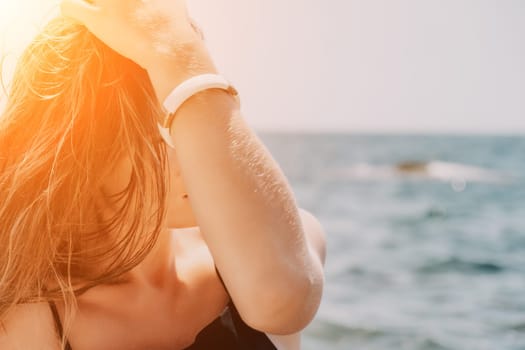 Woman travel sea. Young Happy woman in a long red dress posing on a beach near the sea on background of volcanic rocks, like in Iceland, sharing travel adventure journey