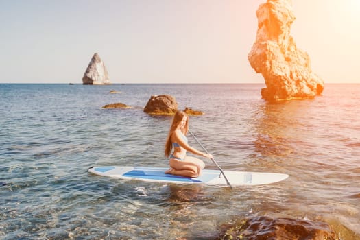 Close up shot of happy young caucasian woman looking at camera and smiling. Cute woman portrait in bikini posing on a volcanic rock high above the sea