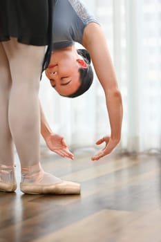 Beautiful woman performing a ballet dance, practicing dance move at home. Dance, art and active lifestyle concept.