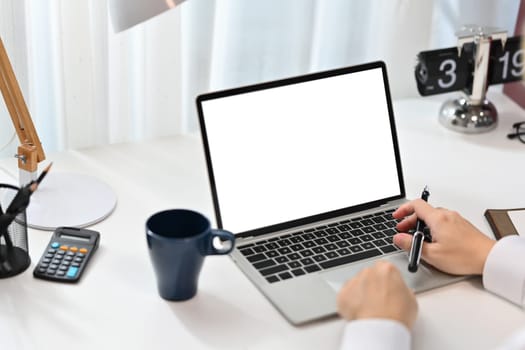 Cropped shot of female entrepreneur working online or checking email on laptop computer.