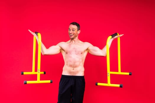 Front and side view photo of strong young man exercising on parallel bars in studio.