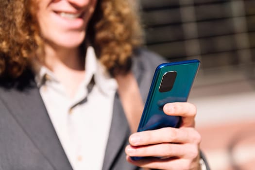 cropped photo of an unrecognizable man using mobile, selective focus on the phone, concept of technology of communication and urban lifestyle, copy space for text