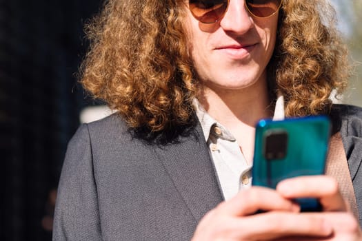 cropped portrait of a young entrepreneur man using mobile phone, concept of technology of communication and urban lifestyle, copy space for text