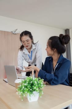 Teamwork of business two colleague analysis with financial data and marketing report graph, Young business woman two co worker discuss for calculating financial document.