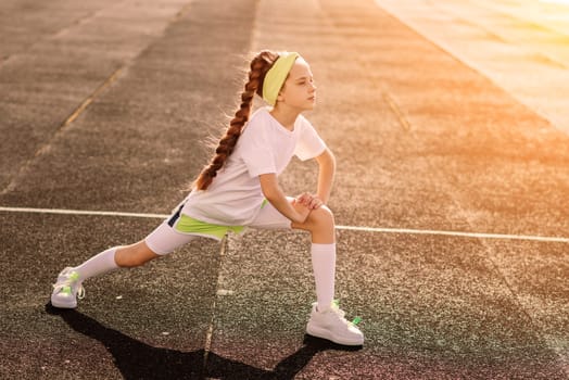 Girl jogging on a sunny summer evening, laying on treadmill, stadium, physical training, back to school, tired.