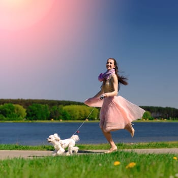 Young woman with her dog. Puppy white dog with it's owner. Concept about friendship, animal and freedom.