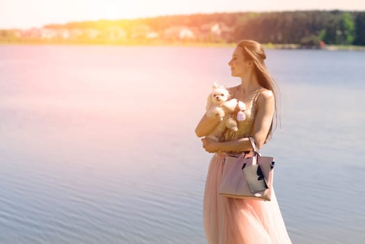 Young girl with her dog. Puppy white dog is running with it's owner. Conception about friendship, animal and freedom.