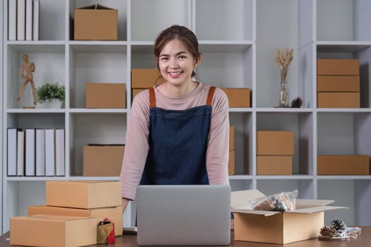 Portrait of Asian young woman SME working with a box at home the workplace.start-up small business owner, small business entrepreneur SME or freelance business online and delivery concept..