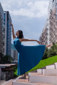 Beautiful Asian ballerina dancing outdoors. Urban landscape