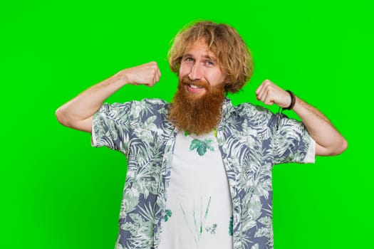 I am strong and independent. Young bearded man showing biceps and looking confident, feeling power strength to fight for rights, energy to gain success win. Guy isolated on green chroma key background
