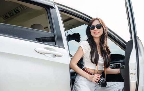 Beautiful young woman travels by car to see nature on vacation. Traveling by private car.