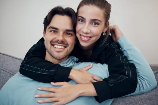Portrait, hug and smile with a couple on a sofa in the living room of their home together for bonding. Relax, love or date with a happy man and woman in their apartment for romance or relationship.