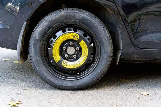 a black passenger car with a spare wheel installed is parked on the road. Security concept. technical assistance on the road