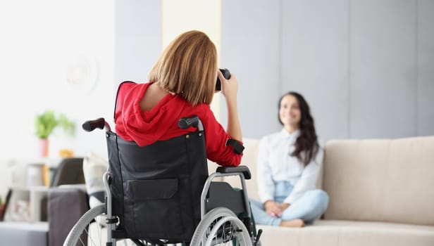 Woman in wheelchair photographs man. Professions for people with disabilities concept